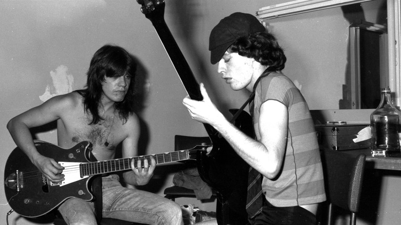 Malcolm and Angus Young playing guitar together in 1976