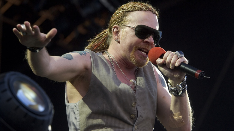 Axl Rose sunglasses dreadlocks singing on stage