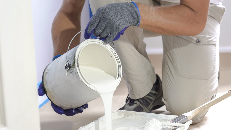 Man with can of white paint