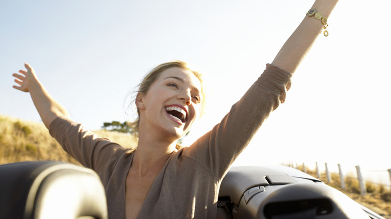 A woman in a car in youthful energetic pose