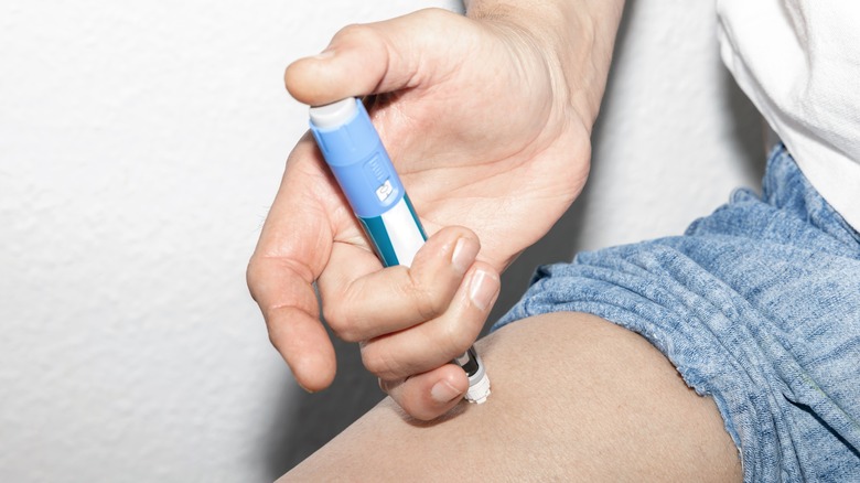 A man injecting insulin into his leg