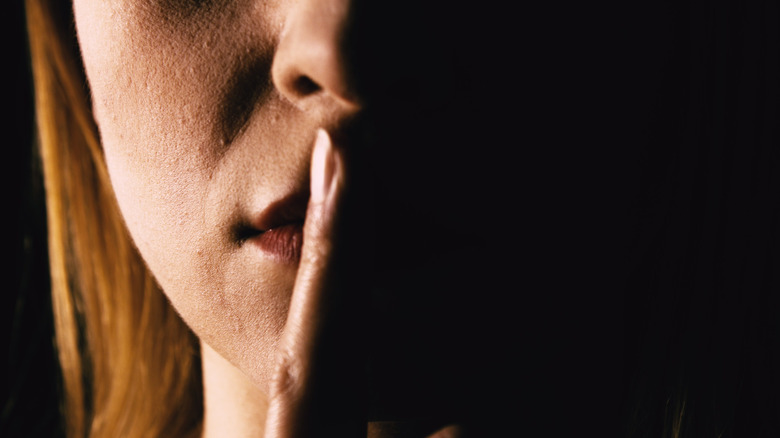 woman with finger to lips