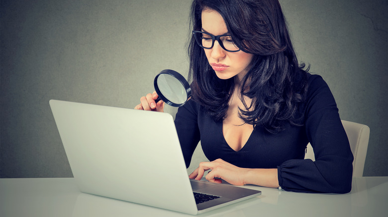 Woman using laptop magnifying glass