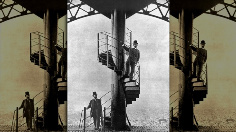 French engineer Alexandre Gustave Eiffel (1832 - 1923), left, poses high on the steps of the completed Eiffel Tower, which he designed for the 1889 Paris Exposition.