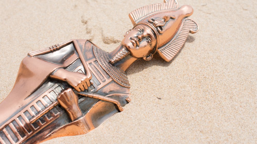 Statue of Osiris on sand