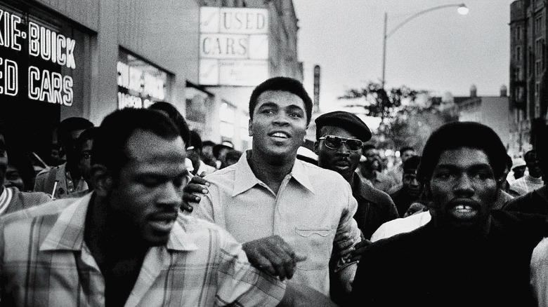 Muhammad Ali walking with Black Panthers