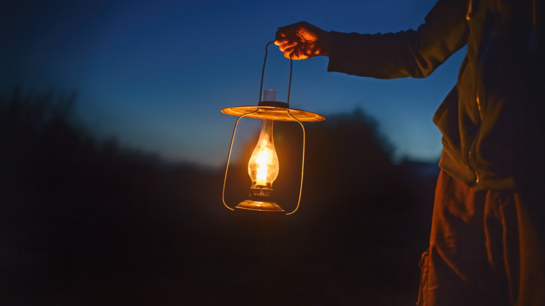 man holding oil lamp