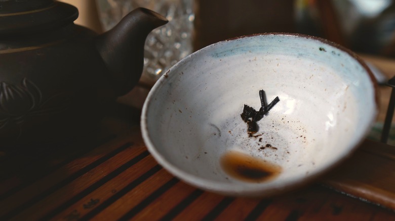 Tea leaves in bottom of white cup