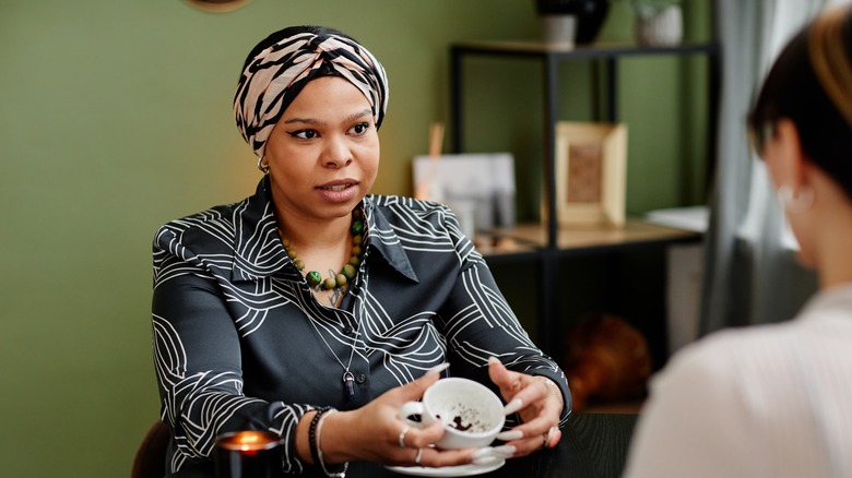 Women discussing tea leaves