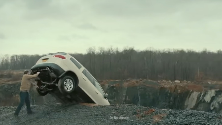 Man pushing car over cliff