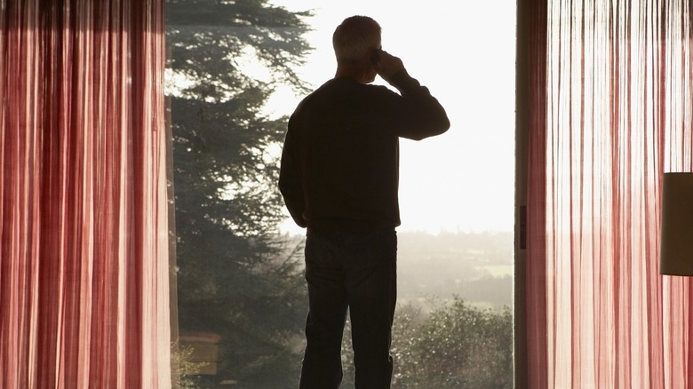 Man making call staring out window