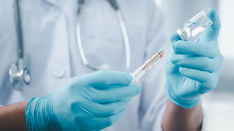  medical personnel with needle and medication