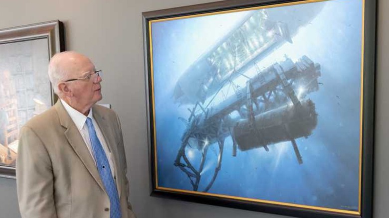 Man suit by painting of Soviet submarine recovery
