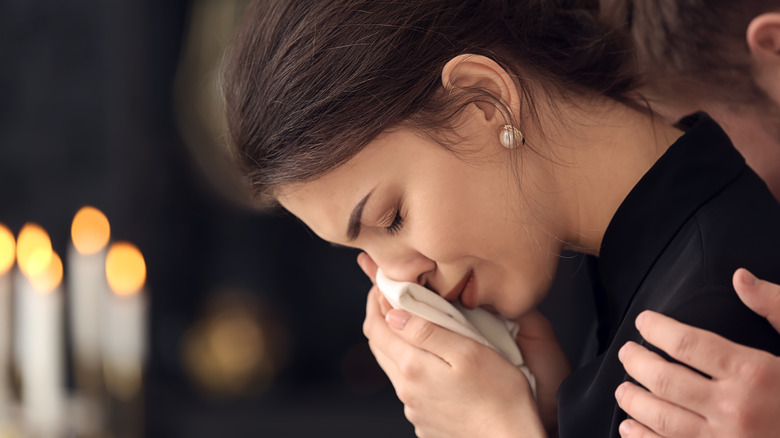 Person crying into handkerchief