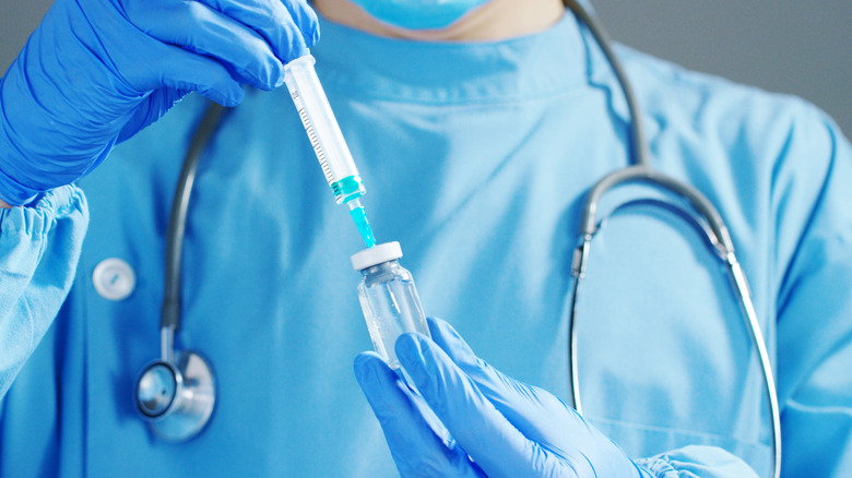 doctor holding syringe and vial