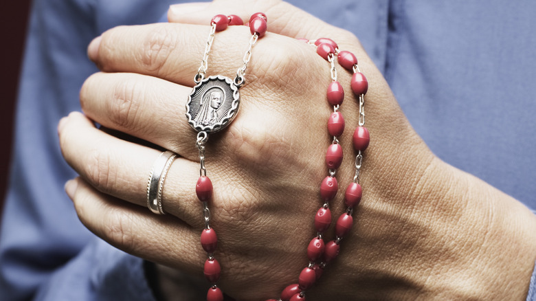 hand holding rosary