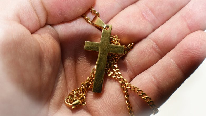 cross necklace in hand