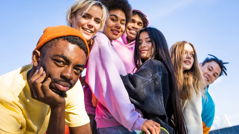 Multicultural group of young friends bonding outdoors and having fun