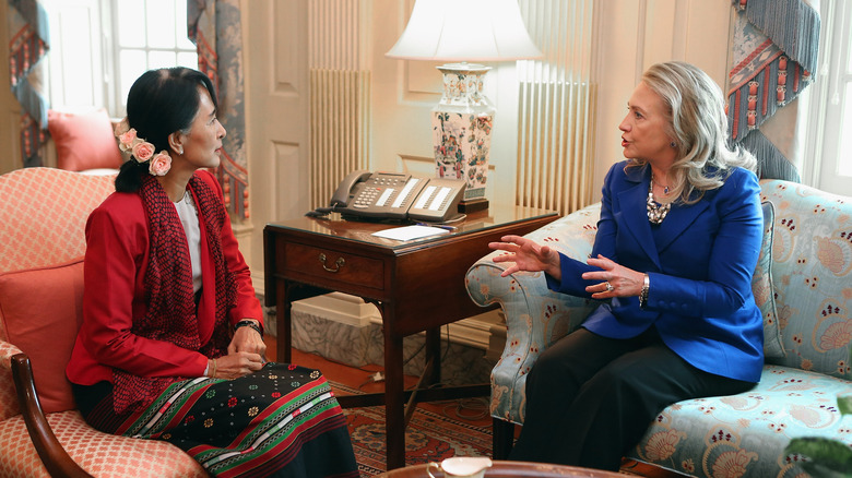 Aung San Suu Kyi sits with Hilary clinton on sofas