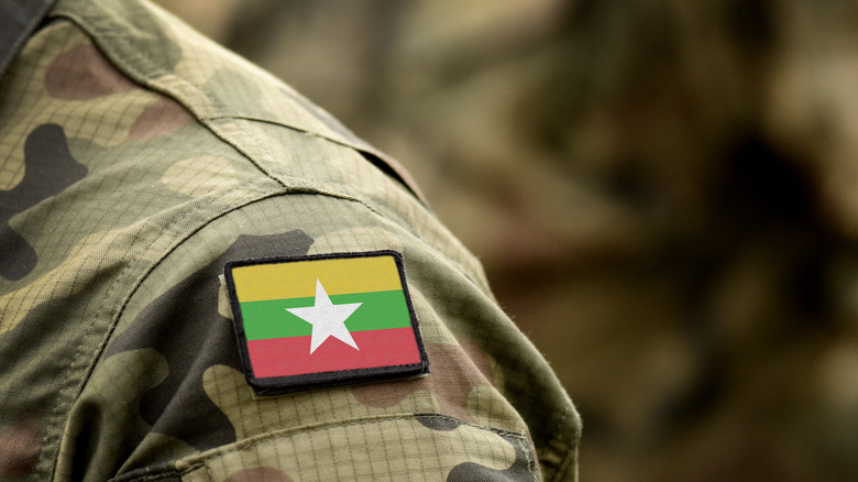 shoulder of Burmese soldier in uniform with flag
