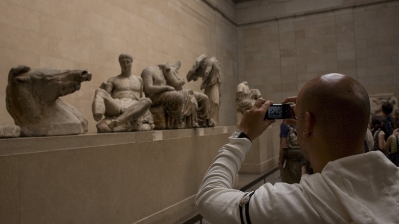 man photographing Elgin marbles