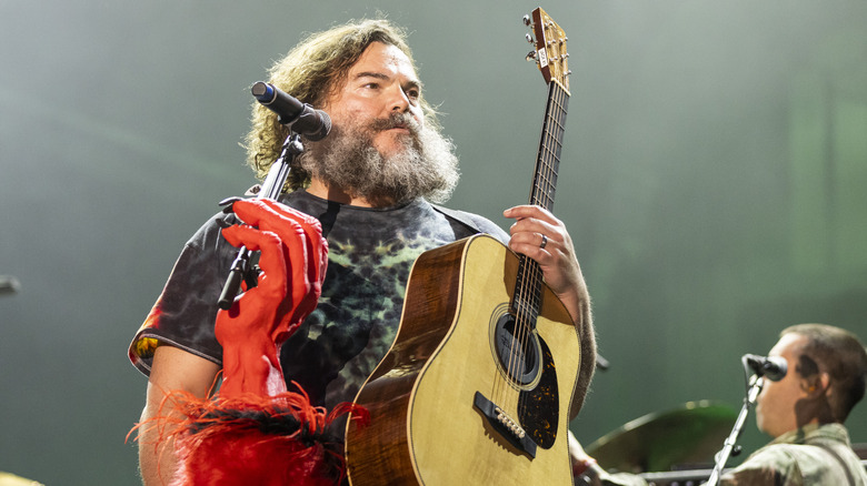 Jack Black carrying guitar onstage