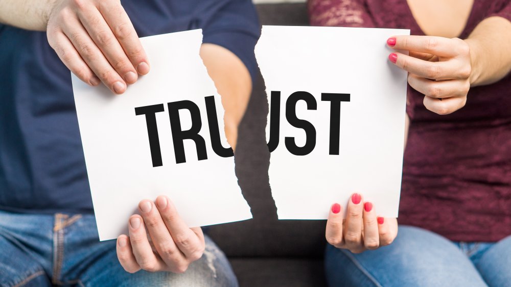 Couple tearing "trust" sign