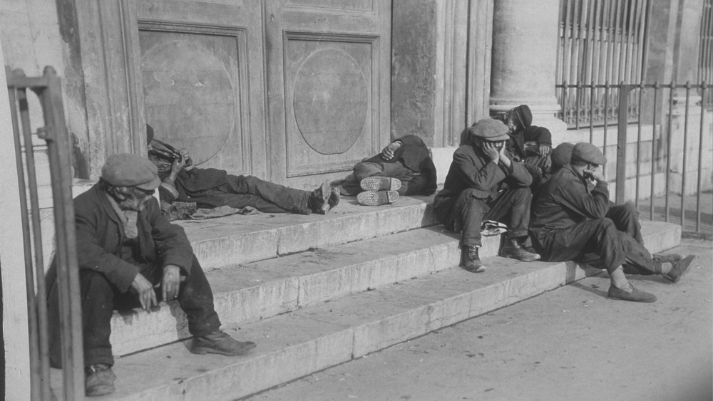 destitute men on the steps of a building 