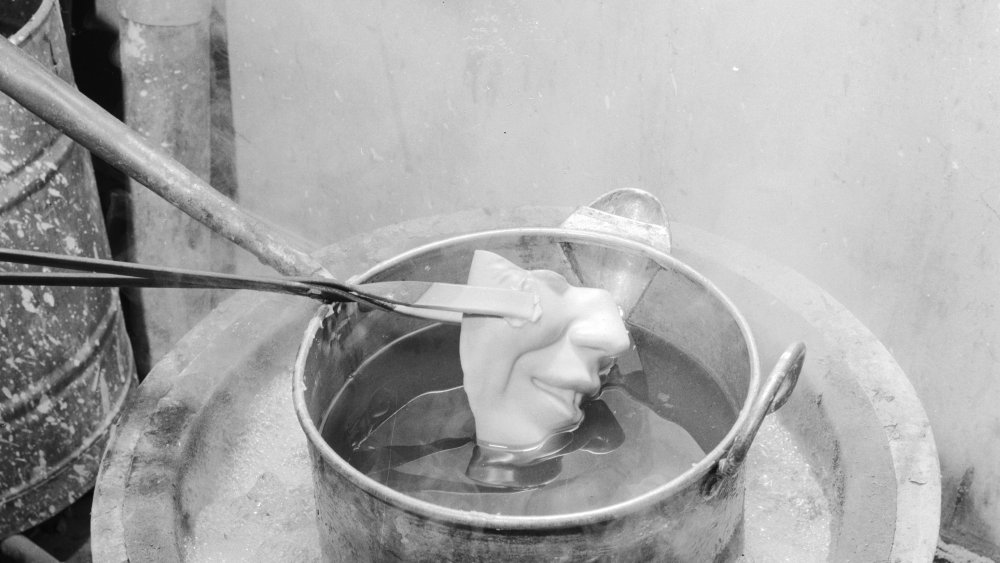 1950: Part of a waxwork's face being lowered in to a melting pot at Madame Tussaud's waxworks museum