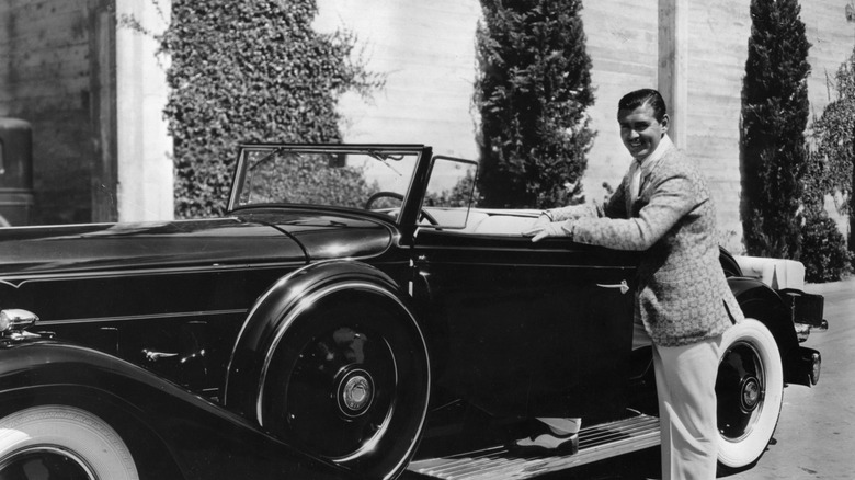 Clark Gable next to a car