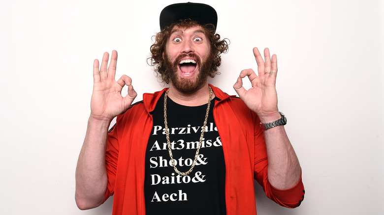 T.J. Miller black cap red jacket OK fingers laughing