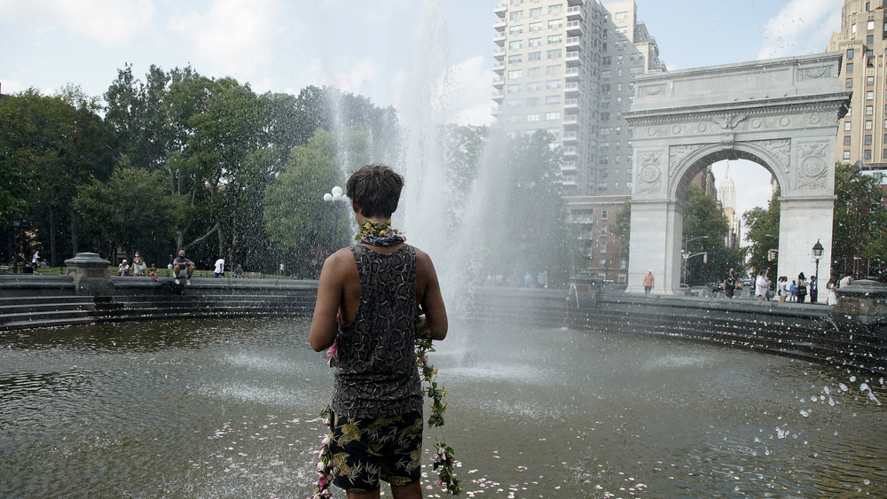 A man wades in the Washington Square Park fountain