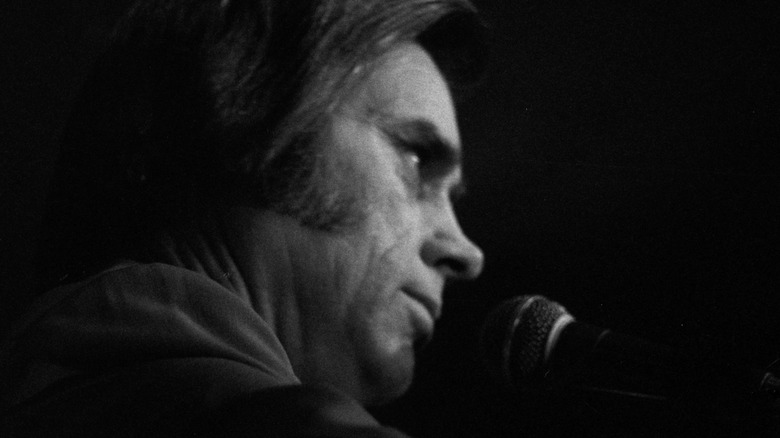 George Jones onstage at microphone