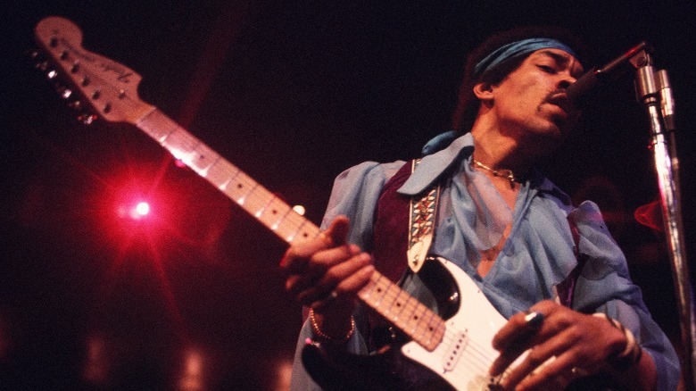 Jimi Hendrix playing the guitar and singing