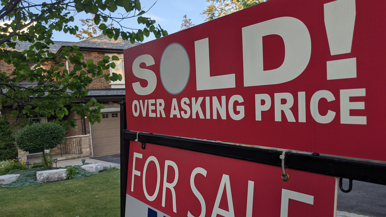 Sign proclaiming house sold over asking price