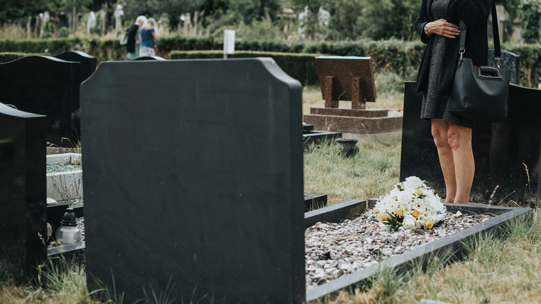 person standing at a grave