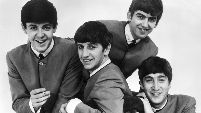 The Beatles all pose and smile