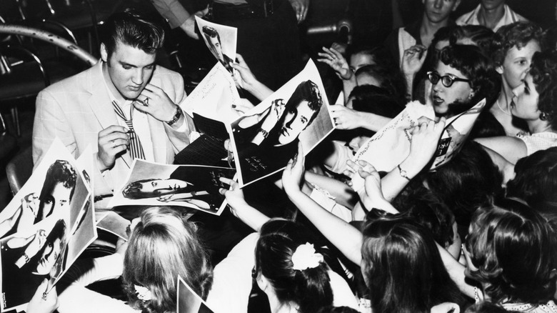 Girls mob Elvis Presley for autographs