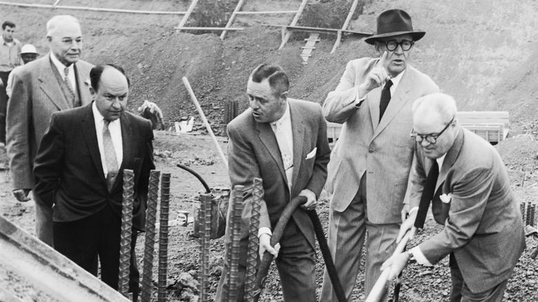 Charles A. Stoneham and men in suits pouring concrete