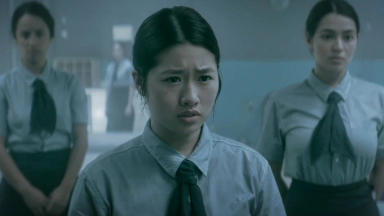 Three female students look in a mirror