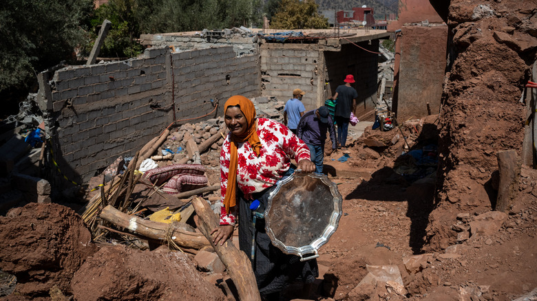 peopole picking through rubble of home Morocco