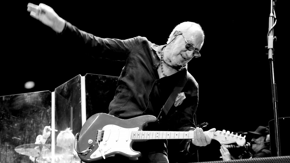 An older Pete Townshend using his signature windmill sturmming