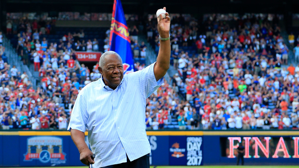 Hank Aaron holds up baseball