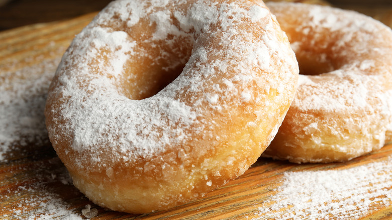 Powdered doughnuts sit on table