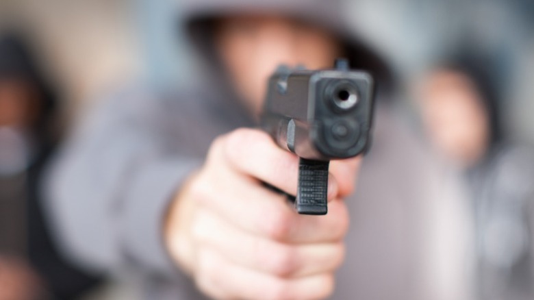 man in hoodie with handgun