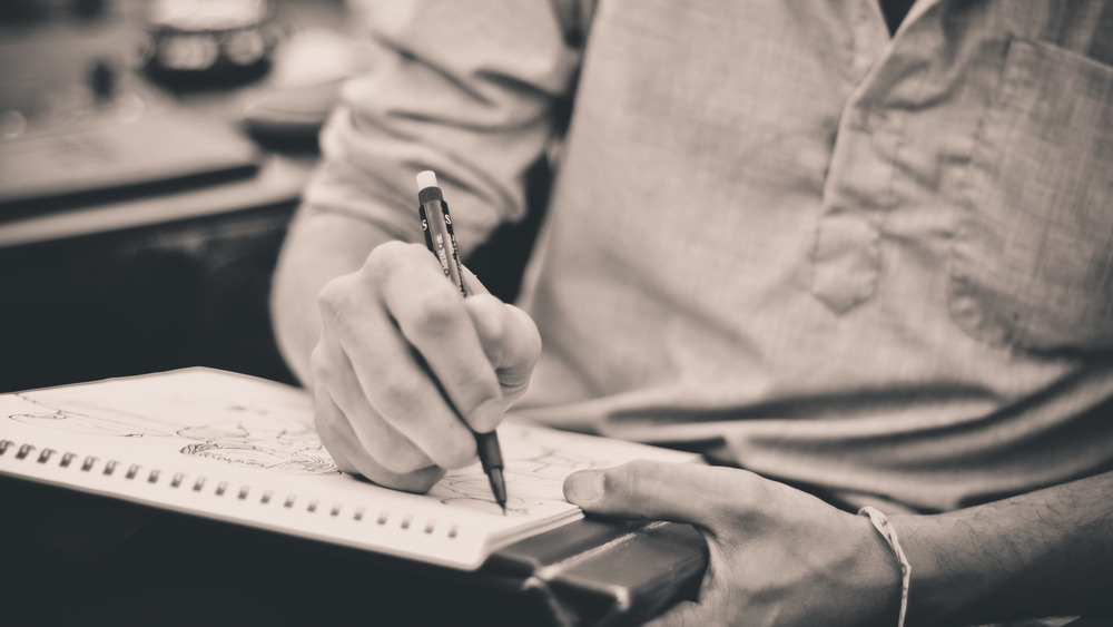 Man sketching in notebook