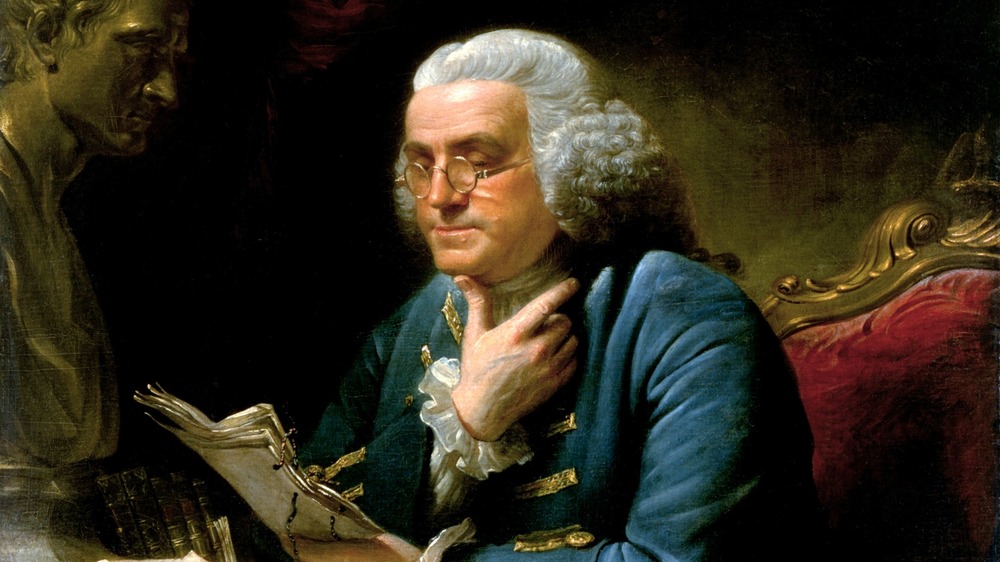 Portrait of Benjamin Franklin looking at papers