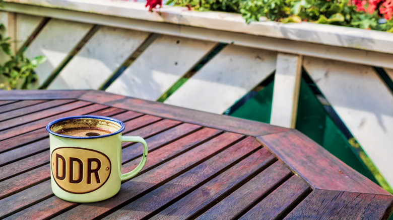 Old tin mug from the DDR on a wooden table