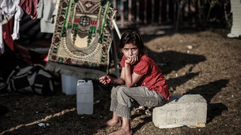 Palestinian refugee sitting on rock