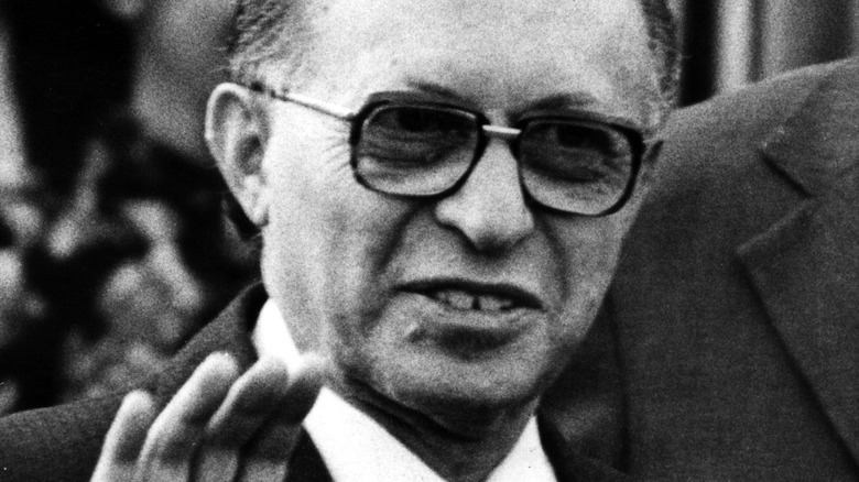 Menachem Begin holding up his hand to the camera